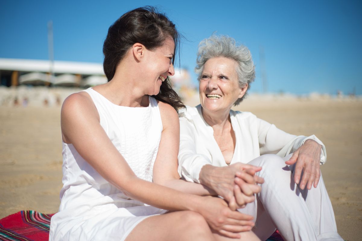 A senior mother laughing with her adult daughter